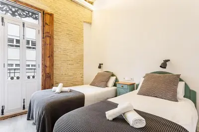 two beds in a room with a window at AIRE Holidays Valencia in Valencia