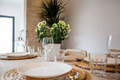 a wooden table with plates and glasses on it at AIRE Holidays Valencia in Valencia