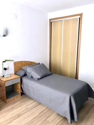a bedroom with a bed and a nightstand and a bed sidx sidx at MiCampus Burjassot 1 Student Residence in Burjasot