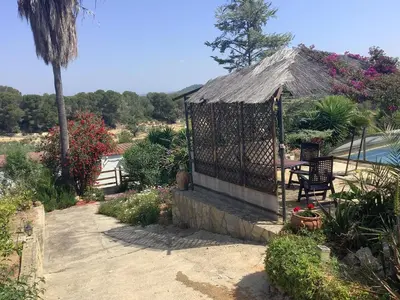 a gazebo with a table and a chair in a garden at Casa Ramona in Valencia