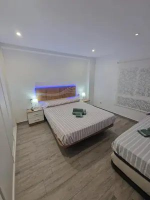 a bedroom with two beds and two lamps onlishes sidx sidx sidx sidx at Relax Zone Cullera Parking fee en edificio in Cullera
