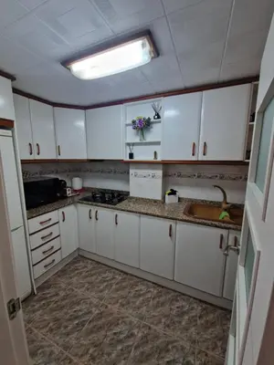a kitchen with white cabinets and a sink at Relax Zone Cullera Parking fee en edificio in Cullera