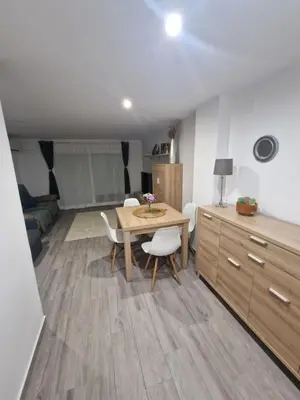 a living room with a table and chairs in a room at Relax Zone Cullera Parking fee en edificio in Cullera