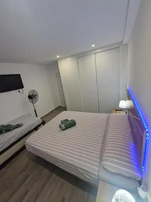 a small bedroom with two beds and a fan at Relax Zone Cullera Parking fee en edificio in Cullera