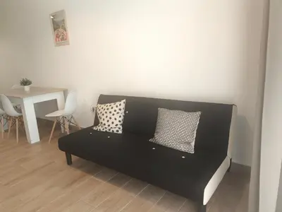 a black couch in a living room with a table at Central Cozy Ground Floor Studio in Valencia