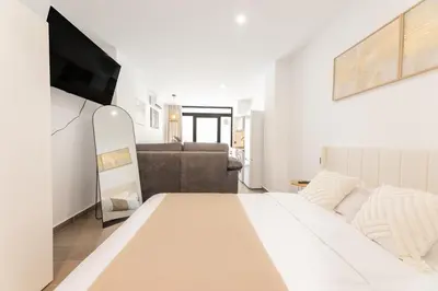 a white bedroom with a bed and a couch at Loft Urban Beach - Cerca del Mar in Valencia