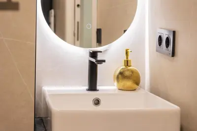 a bathroom sink with a mirror and a bottle on it at Loft Urban Beach - Cerca del Mar in Valencia