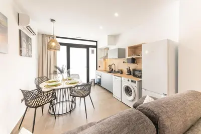 a living room with a couch and a table and chairs at Loft Urban Beach - Cerca del Mar in Valencia