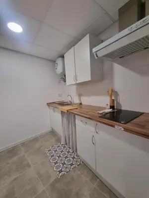 a kitchen with white cabinets and a wooden counter top at Rural studio in Cortez de Pallas