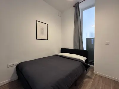 a small bedroom with a bed and a window at Habitación privada con baño privado I in Valencia