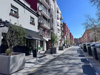 an empty city street with a row of trash cans at Habitación privada con baño privado I in Valencia