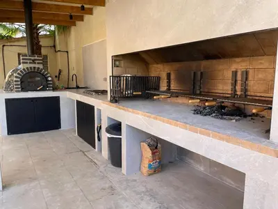 a large kitchen with a stove and a counter top at Villa con barbacoa para familias in Mareny Blau