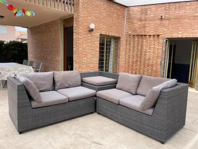 a wicker couch sitting on a patio at Villa con barbacoa para familias in Mareny Blau
