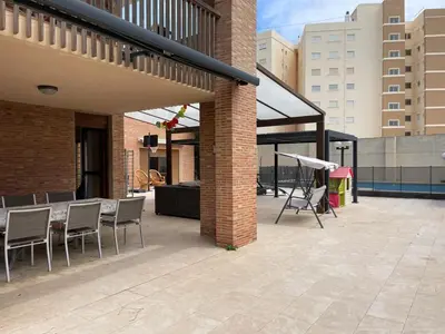 a patio with chairs and a table on a building at Villa con barbacoa para familias in Mareny Blau