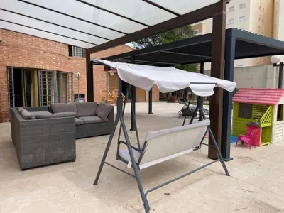 a patio with a white umbrella and a couch at Villa con barbacoa para familias in Mareny Blau