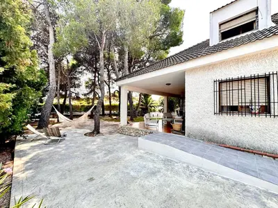 a patio with a hammock outside of a house at Villa El Plantio in Pla del Pou