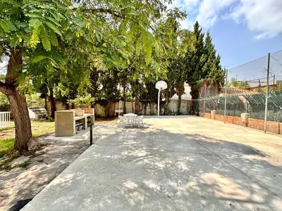 a court with a basketball hoop and a tree at Villa El Plantio in Pla del Pou
