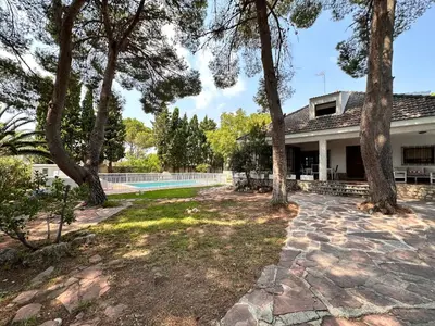 an exterior view of a house with trees and a swimming pool at Villa El Plantio in Pla del Pou