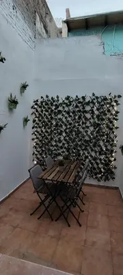 a room with a table and chairs and a wall filled with wood at Beachside apartment in Valencia