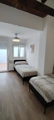 a bedroom with three beds in a room at Beachside apartment in Valencia