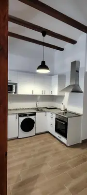 a large kitchen with white cabinets and a sink at Beachside apartment in Valencia