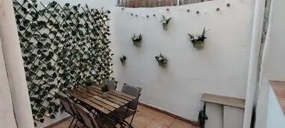a room with a table and chairs and a wall with potted plants at Beachside apartment in Valencia
