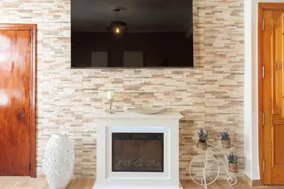 a living room with a fireplace with a flat screen tv at Apartamento Estilo Rustico Buñol - ELPATIO- in Buñol