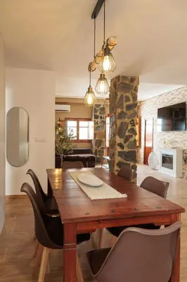 a dining room with a wooden table and chairs at Apartamento Estilo Rustico Buñol - ELPATIO- in Buñol