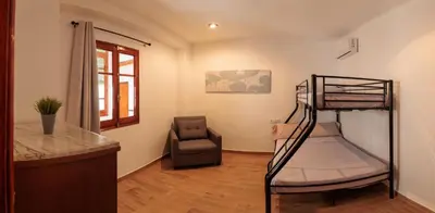 a bedroom with a bunk bed and a chair at Apartamento Estilo Rustico Buñol - ELPATIO- in Buñol