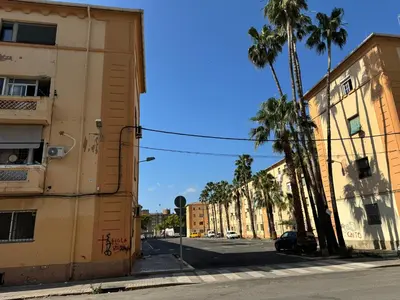 an empty city street with palm trees and buildings at Habitacion privada con baño privado III in Valencia