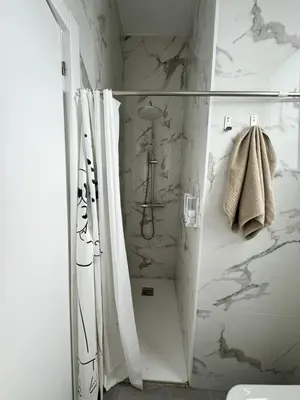 a bathroom with a shower with white marble walls at Habitacion privada con baño privado III in Valencia