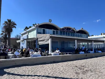 people sitting at tables at a restaurant on the beach at Habitacion privada con baño privado III in Valencia