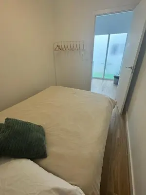 a bed in a room with a large window at Habitacion privada con baño privado III in Valencia