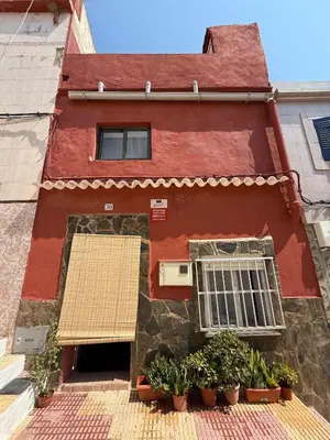 a red building with potted plants in front of it at Casita con vistas al Castillo de Cullera in Cullera
