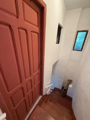 a red door in a hallway next to a stairs at Casita con vistas al Castillo de Cullera in Cullera