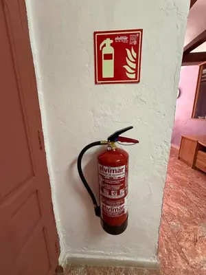 a fire extinguisher hanging on a wall next to a door at Casita con vistas al Castillo de Cullera in Cullera