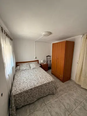a bedroom with a bed and a wooden cabinet at Casita con vistas al Castillo de Cullera in Cullera