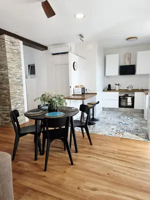 a kitchen and living room with a table and chairs at La Marina de Coup de Coeur Appartments in Valencia