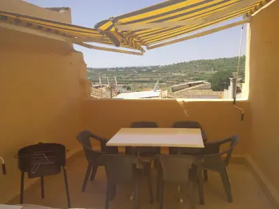 a table and chairs in a room with a window at Ca'l Suecà in Chella