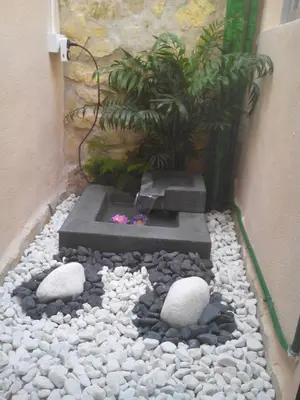 a rock garden with a fountain and a plant at Ca'l Suecà in Chella