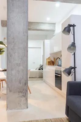 a living room with white walls and a concrete pillar at Manya Valencia by Concept Flats in Valencia