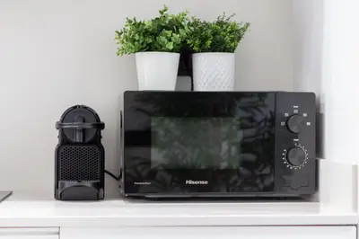 a microwave sitting on a counter with two potted plants at Manya Valencia by Concept Flats in Valencia