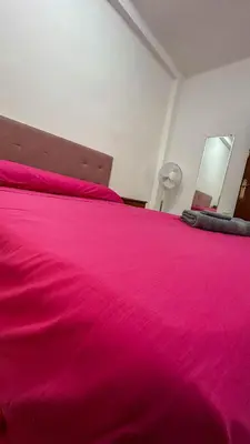 a bed with a pink bedspread on top of it at Kmilo in Valencia