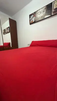 a bedroom with a red bed with a red blanket at Kmilo in Valencia