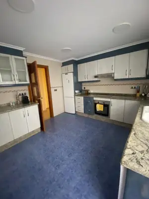a kitchen with white cabinets and a blue floor at Casa Flare Apartmento para 6 personas en Cheste in Cheste