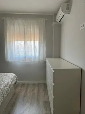a bedroom with a bed and a dresser and a window at District Key - Valencia, Manuel Candela in Valencia