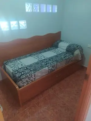 a bed with a wooden frame in a room at Apartamento Canet de Berenguer con terraza exterior a 100m de la playa in Canet de Berenguer