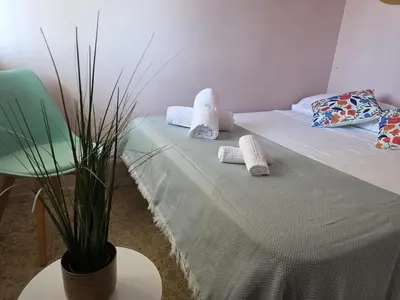 a bedroom with a bed with towels and a potted plant at Ca Ulises Frente al mar, pensado para desconectar in Valencia