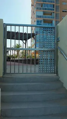 a staircase with a metal railing and a gate at Ca Ulises Frente al mar, pensado para desconectar in Valencia