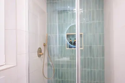 a bathroom with a shower with blue tiles at Apartamento con patio playa cabanyal in Valencia